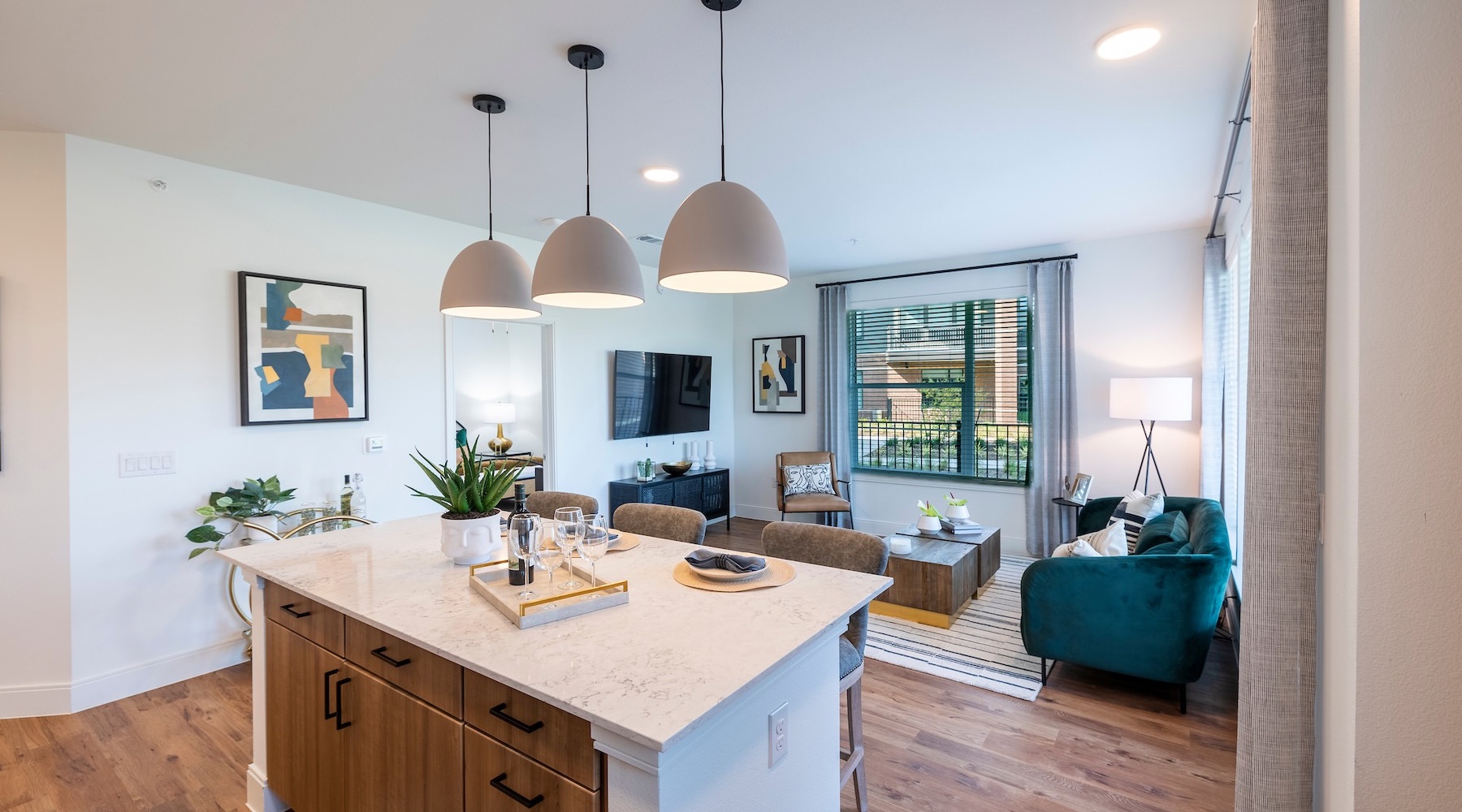 a kitchen and living room with an island, tv and a couch