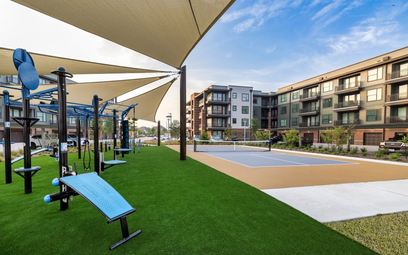 an outdoor activity area with a playground and a tennis court